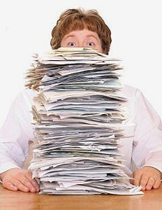 A great big pile of invoices that nearly towers over a woman. Don’t let your paper invoices take over your finance department. Every financial throughout the UK can benefit from out invoice scanning services