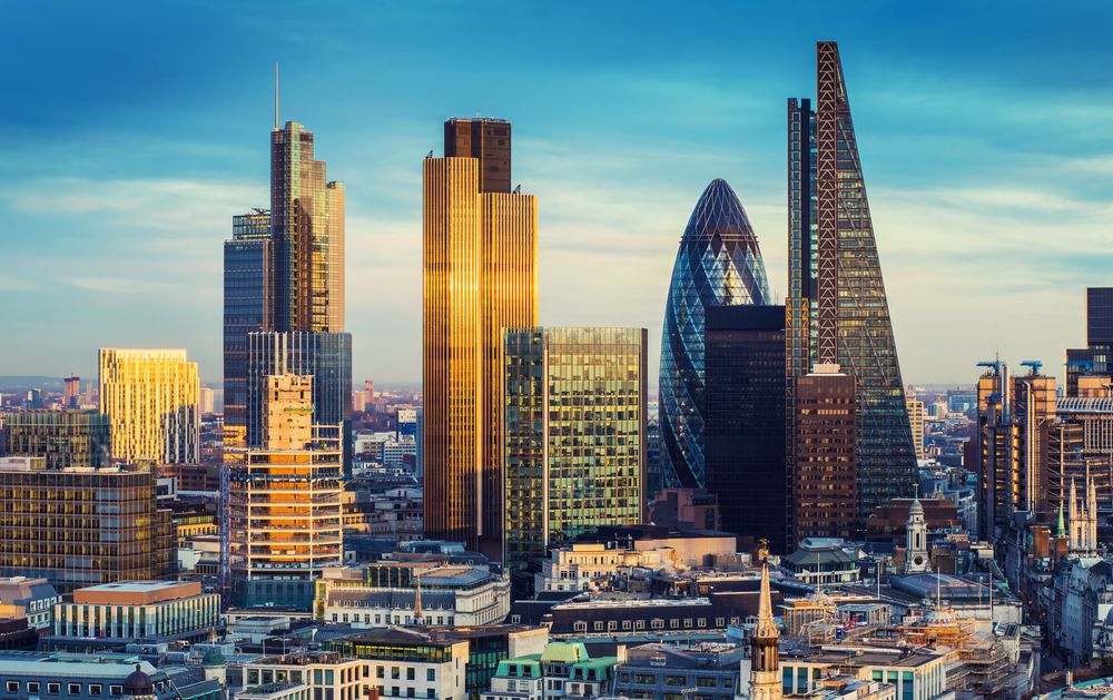 London, England - The banking district in the heart of London, renowned for its towering skyscrapers and iconic landmarks, bathed in the glow of sunset under a blue sky - UK