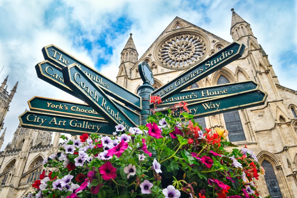 Street sign with directions to landmarks in the english city of York - With the York Cathedral on the background