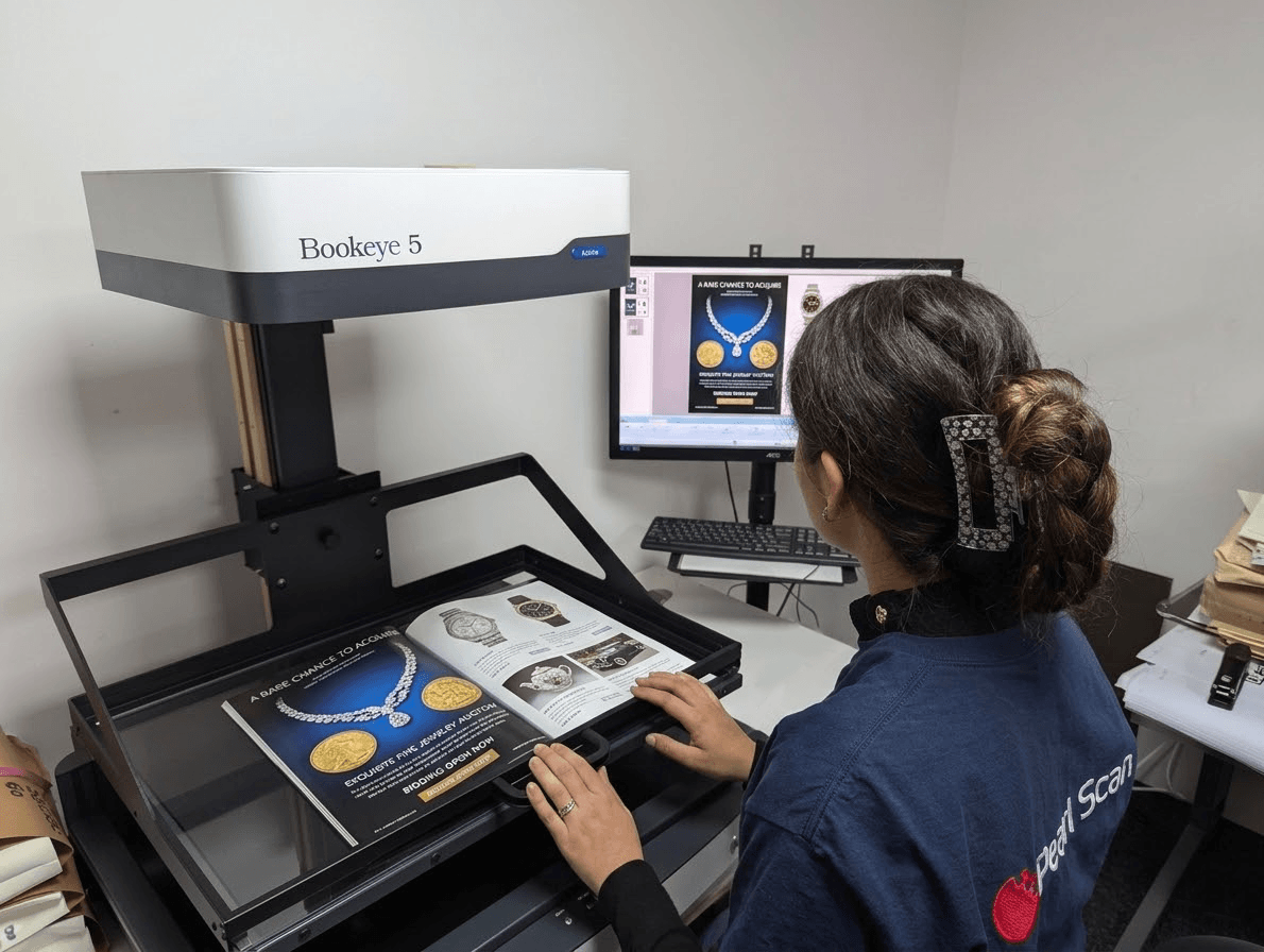Scanning operator digitising glossy magazines using Book Eye 5 scanner