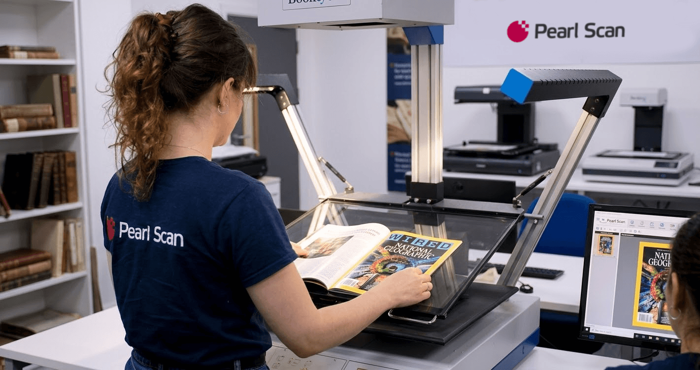 A technician in a dark blue Pearl Scan uniform scanning a glossy magazine with an overhead scanner.